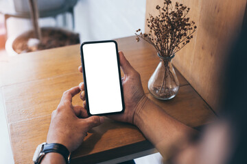 cell phone mockup blank white screen.man hand holding texting using mobile on desk at coffee shop.background empty space for advertise.work people contact marketing business,technology