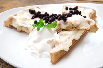 Delicious Belgian waffles with vanilla and blueberry topping in the confectionary of Budapest, Hungary