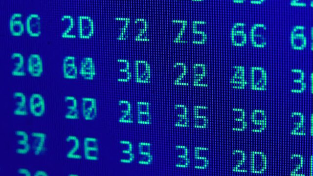 Close up on computer screen binary code on blue background.