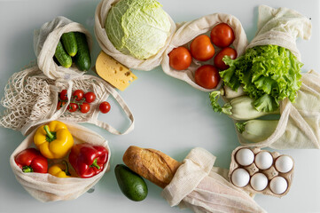Woman's hand, holding a reusable grocery bag with vegetables on a kitchen at home and takes cabbage out. Zero waste and plastic free concept. Mesh cotton shopper with vegetables. Ecology.