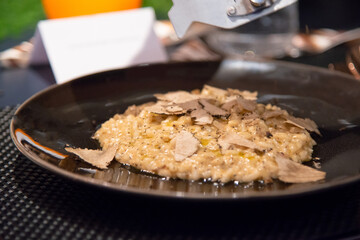 selective focus of risotto with sliced black truffle