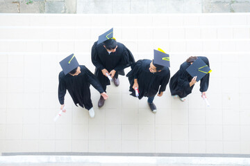 top view of people students walk with the graduation gowns and cap in the line at corridor of...