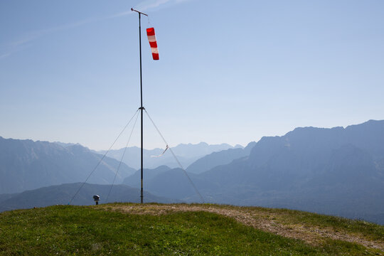 Starting point near Garmisch Partenkirchen of paragliders with red and white windsocks. In the background mountain peaks in the German Alps