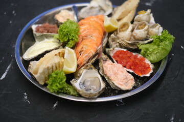 a plate of assorted seafood on a black background