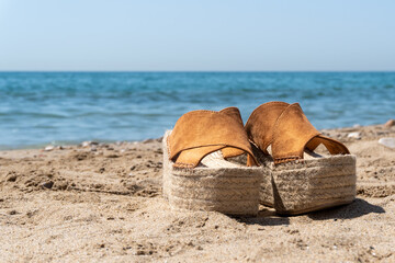 Close up shot of women's shoes on the beach with blurred background