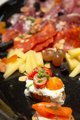 close up of bruschetta on variety of  italian cold cut board