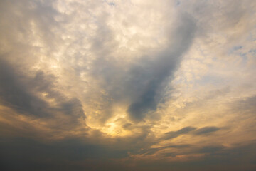 Blue skies with cumulus clouds are illuminated by the sun.