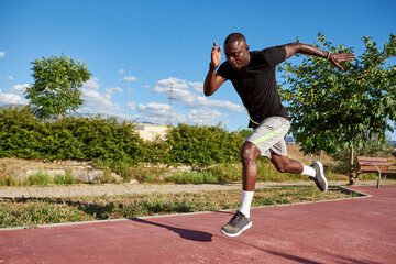 African athlete running on a sunny summer day.