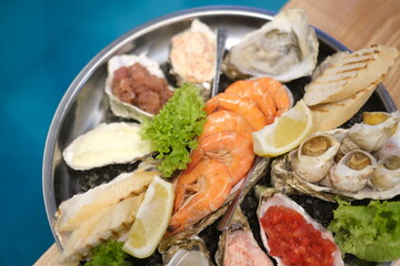 a plate of assorted seafood on a blue background in top view