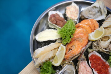 a plate of assorted seafood on a blue background in top view