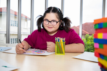 Young girls disabilities Or Down's syndrome learning about drawing shape and bright smile for...