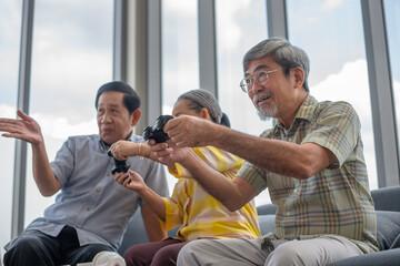 group of asian retired enjoy playing video game together in living room