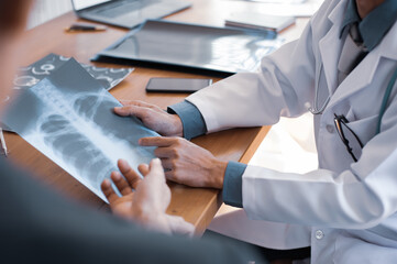 The doctor is analyzing and clarifying images of the patient's lung X-rays.