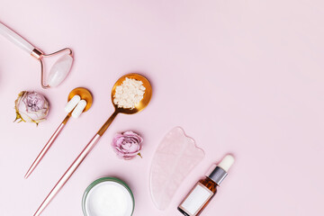 Skincare accessories on pink background.