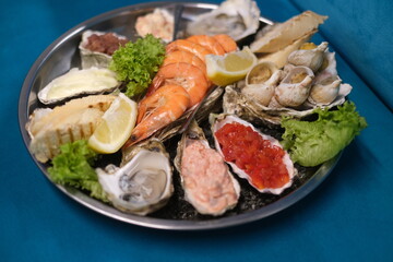 a plate of assorted seafood on a blue background in top view