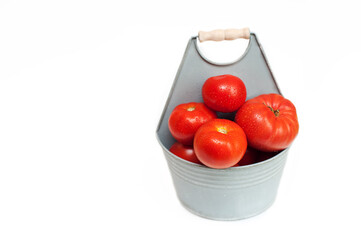  tomatoes in a gray basket on a white background. free space on the left side