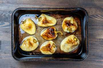 Baked yellow peppers in the baking pan, close up, top view. Vegetarian food.