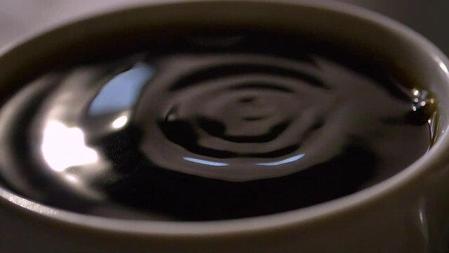 Coffee droplet in close up slow motion bounces back