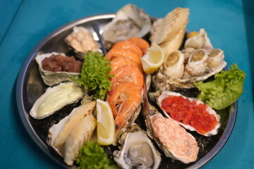 a plate of assorted seafood on a blue background in top view