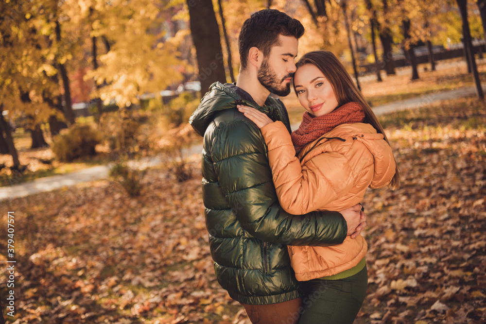 Poster Photo of affectionate passionate couple guy hug kiss girlfriend in autumn september forest town park wear coats scarf