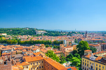 Naklejka na ściany i meble Aerial view of Verona city historical centre Citta Antica with red tiled roof buildings. Panoramic view of cityscape of Verona town. Blue sky background copy space. Veneto Region, Northern Italy