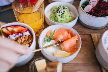 Anonymous person eating tasty salmon dish from small bowl