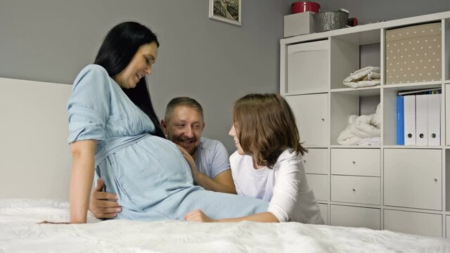 Pregnant mom, dad and teenage son. Happy family in anticipation of their second child.