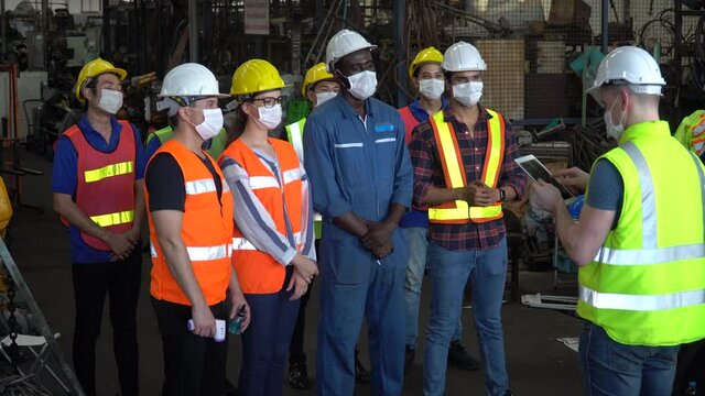 group of factory workers wear protective face mask meeting in industrial factory protect for pollution and coronavirus pandemic or covid 19 outbreak