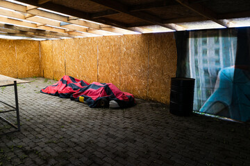 two kart cars under covers are in an empty box. abandoned karting