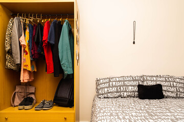 Double bed and closet with men's and women's clothing