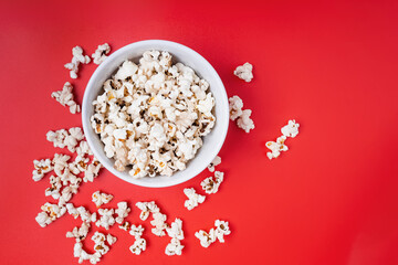 Fototapeta na wymiar Bowl of popcorn on red background