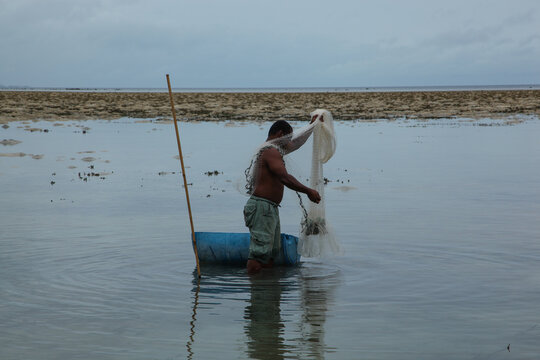 Fisherman with fishing net in Palau on local reef