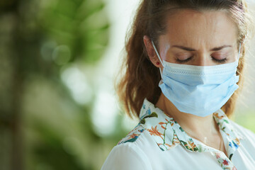 sad stylish 40 years old woman in blouse with medical mask