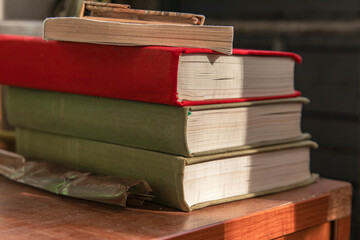 Old books on a wooden nightstand.