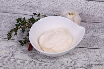 Mayonnaise sauce in the white bowl served thyme and garlic