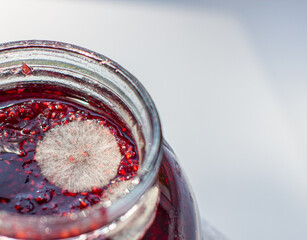 Mold in a jar of raspberry jam. Hazardous to health. - obrazy, fototapety, plakaty