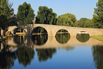 Fototapeta na wymiar Old bridge over river, in town of Spain