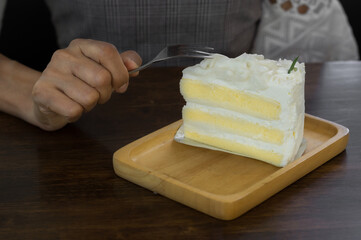 Woman eating white coconut cake on plate.