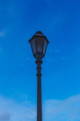 Fototapeta na wymiar an old street lamp on sky background