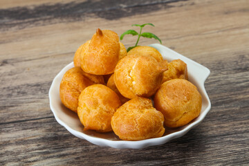 Sweet tasty profiteroles heap in the bowl
