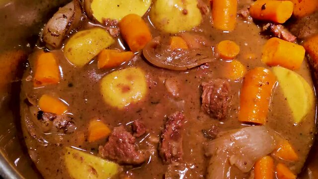 Making the best red wine beef stew including chuck roast, red wine, potatoes, and carrots