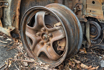 Rusty car wheel with brake caliper close up