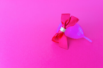 Menstrual cup as a gift, flat lay on pink background. Women Health. Picture with place for text