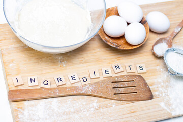 making dough for bread or homemade baked goods. ingredients on a wooden table. inscription:...