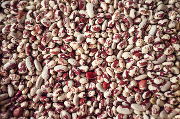 Exotic colorful mexican beans on wicker basket. Top view of legumes. Concept of beans food. Exotic beans on wooden table. Rustic background of beans. Colorful legumes on rustic setting