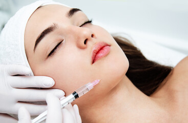 Woman getting cosmetic. injection. Beauty injections and cosmetology.  Young woman in beauty salon sloseup