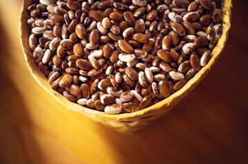 Exotic colorful mexican beans on wicker basket. Top view of legumes. Concept of beans food. Exotic beans on wooden table. Rustic background of beans. Colorful legumes on rustic setting