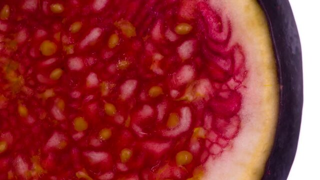Press Down on the Piece of  Fig. Pulp of ripe figs is compressed and crushed close-up on a bright white background, creating a juicy splash of pulp and juice. Shooting at 120 fps