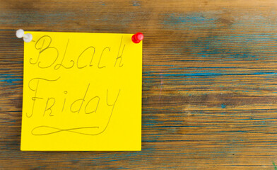 The words Black Friday handwriting text close up on yellow sticky note with copy space.