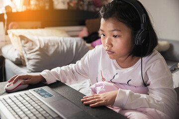 Asian children using laptop to learning and doing homework at home. Happy Thai Students study online for study to the exam. Education concept.